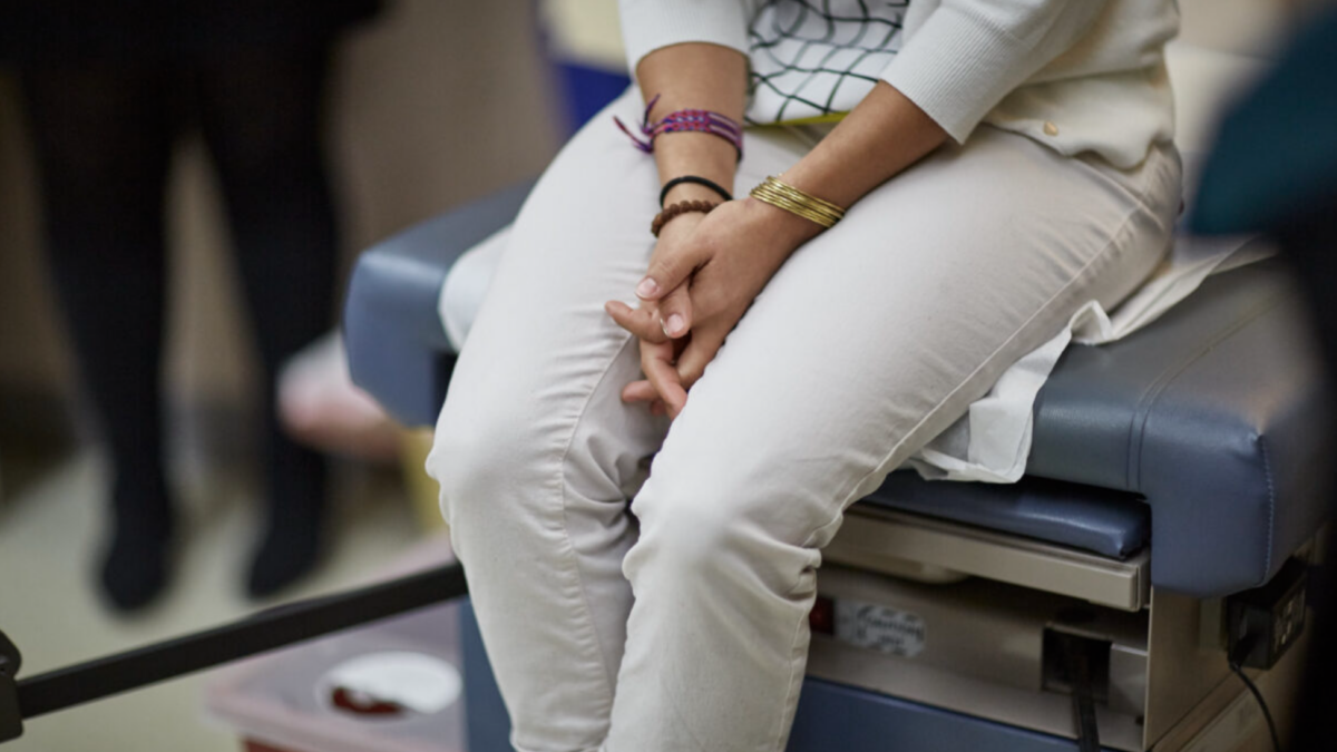 woman sitting on exam table at abortion facility